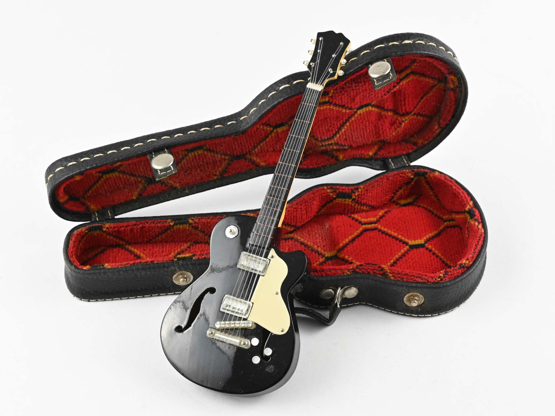 Model gitary oparty o otworzony futerał gitarowy
