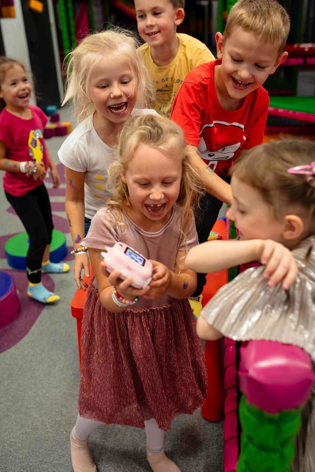 Urodziny Helenki w sali zabaw Gumiś w Warszawie roześmiane dzieci pokazują sobie zdjęcia w aparacie fotograficznym