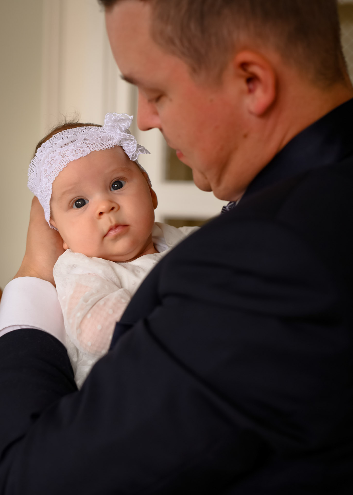 Portret dziecka trzymanego przez ojca dziecko patrzy się w obiektyw ojciec czule parzy na córkę