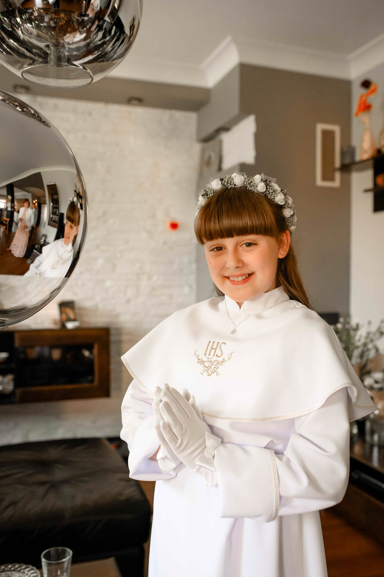 Dziewczynka w domu pozuje do zdjęcia przed wyjśćiem na uroczystość Komunii Świetej